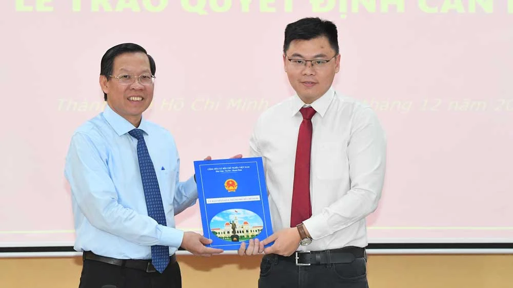 Chủ tịch UBND TPHCM Phan Văn Mãi trao quyết định cho TS Trương Minh Huy Vũ. Ảnh: VIỆT DŨNG