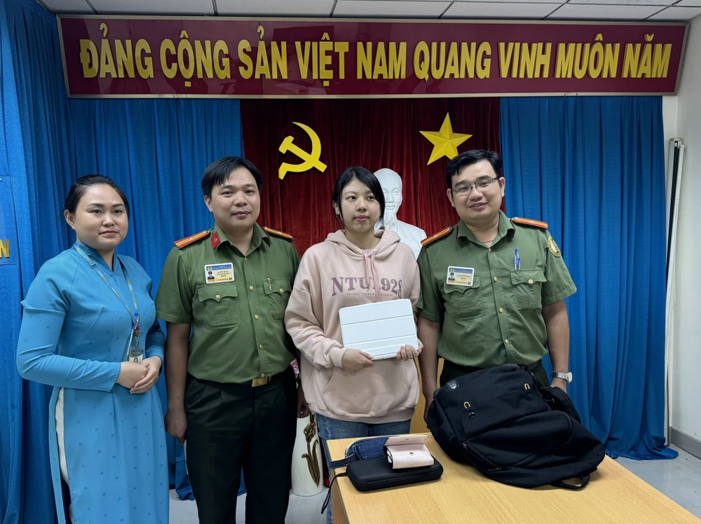 Cô Huang Huy Yu xúc động nhận lại tài sản từ Thiếu tá Trần Minh Cường (bìa phải) 