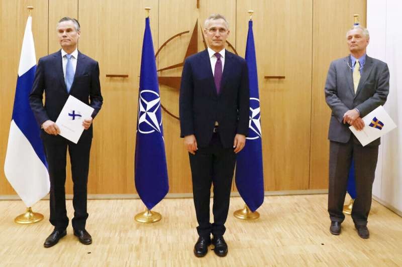 芬蘭大使（左）及瑞典大使（右）與北約秘書長史托騰伯格，共同出席兩國正式申請加入北約的儀式。（美聯社）