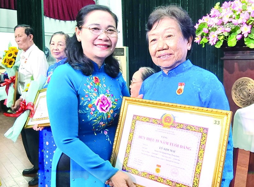 市人民議會主席阮氏麗向李金梅黨員頒發55年黨齡紀念章。