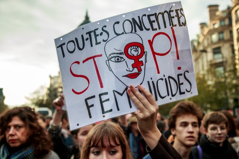 在巴黎街頭，一名女子高舉寫有「停止殺害女性」的牌子。  歐新社 / 達志影像