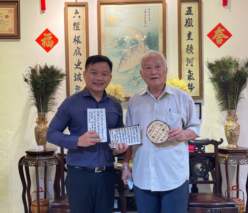 鄔有發書法家（右）向華人文化收藏家麒麟贈送作品。