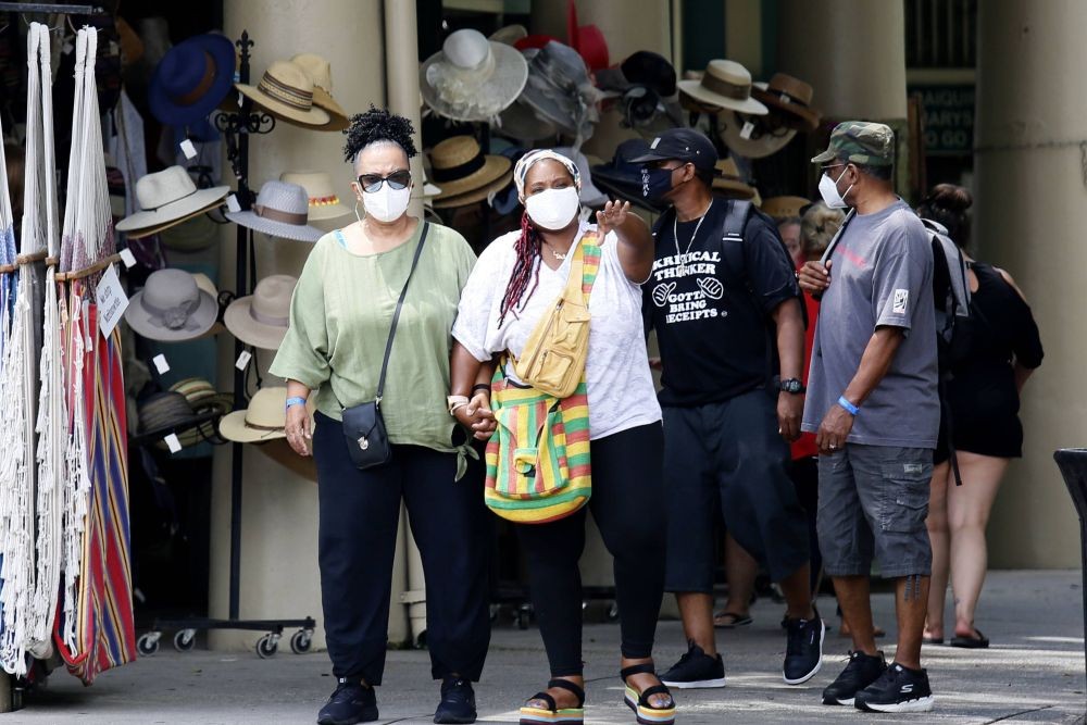 人們在美國路易斯安那州新奧爾良市戴著口罩出行。（圖：新華社）