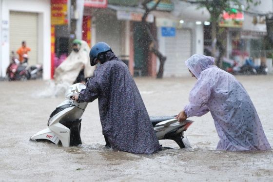 芹苴市13日一清早就傾盆大雨，又逢潮汛，導致到處一片汪洋，人們出行困難。（圖：Zing）