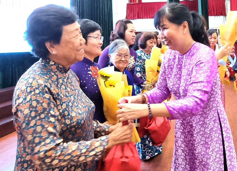 第五郡婦聯會主席陳氏雪幸向華人婦女 李金梅女士贈送鮮花。