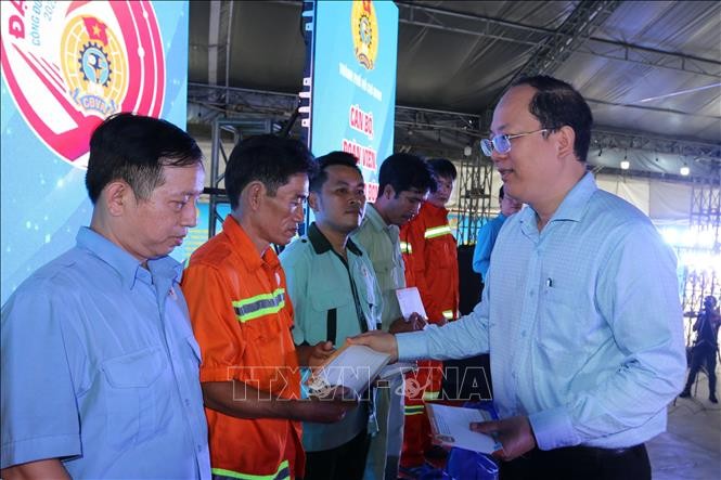 市委副书记阮胡海向贫困工人颁发礼物。