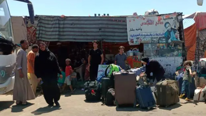 逃离苏丹的难民抵达埃及南部阿斯旺省的一处汽车站。（图片来源：新华社）