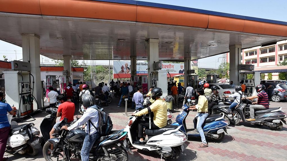 印度新德里，当地民众在一处加油站内排队加油。