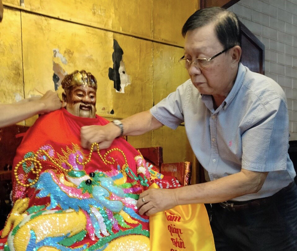 二府会馆副理事长谢忠成为神像更换袍冠。