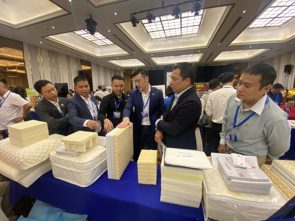 万成乳胶床垫公司副总经理杨庆云（右三）向参观者介绍产品。