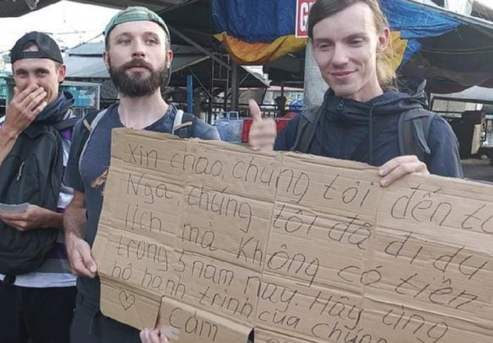 Nhóm 3 người đàn ông (tự giới thiệu đến từ Nga) đứng cầm bảng xin tiền gần chợ Dương Đông, Phú Quốc (Kiên Giang). Ảnh: CTV