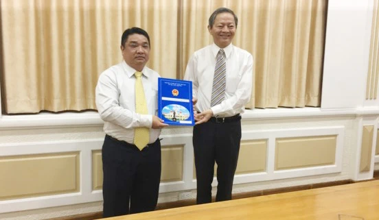 Phó Chủ tịch UBND TPHCM Lê Văn Khoa trao quyết định cho ông Võ Khánh Hưng (phía bên trái).
