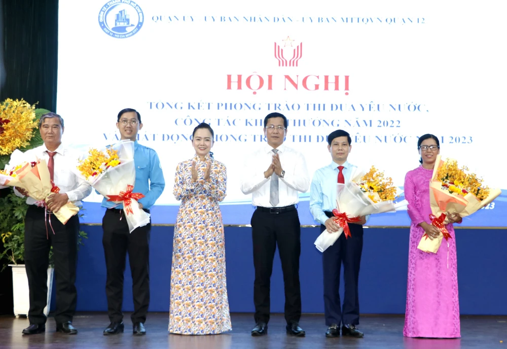 Bí thư Quận ủy quận 12 Trần Hoàng Danh và Phó Giám đốc Sở Nội vụ TPHCM Ngô Thị Hoàng Các tặng hoa chúc mừng các tập thể được nhận cờ thi đua của TPHCM
