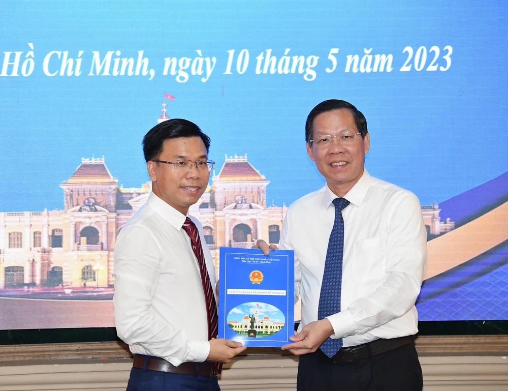 Chủ tịch UBND TPHCM Phan Văn Mãi trao quyết định bổ nhiệm cho ông Phạm Trung Kiên. Ảnh: VIỆT DŨNG