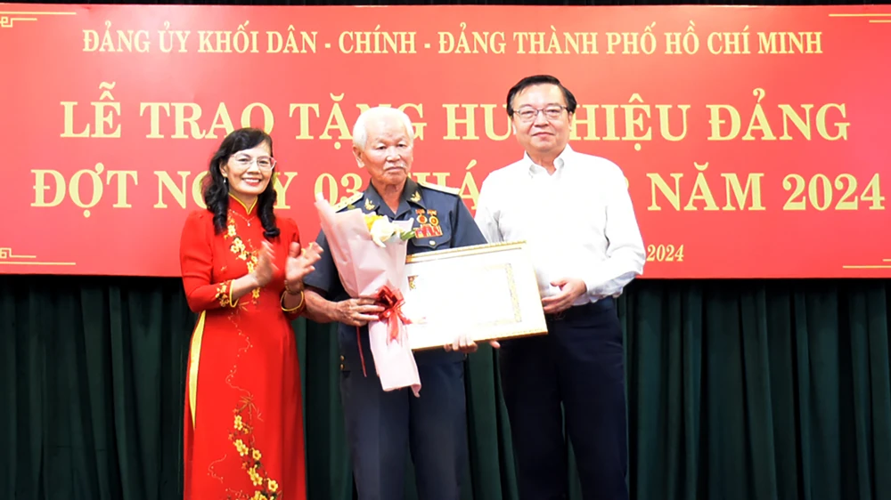 Đồng chí Lê Hồng Sơn và đồng chí Nguyễn Thị Kim Dung trao Huy hiệu 60 năm tuổi Đảng đến đồng chí Nguyễn Kim Khôi, Đảng bộ Liên hiệp các Hội Khoa học và Kỹ thuật TPHCM