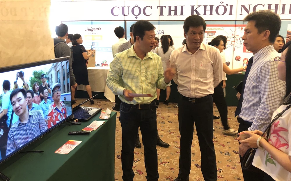Ông Nguyễn Việt Dũng, Giám đốc Sở KHCN TPHCM (trái) tìm hiểu sản phẩm du lịch của các nhóm khởi nghiệp