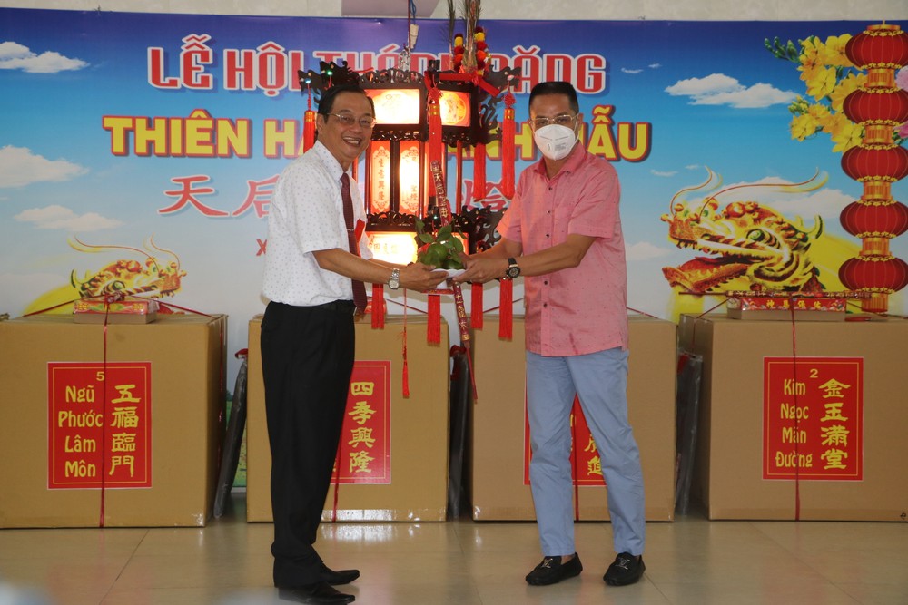 天后宮副理事長陳永安（左）向安強木器公司經理黎德義移交“生意興隆”聖燈。