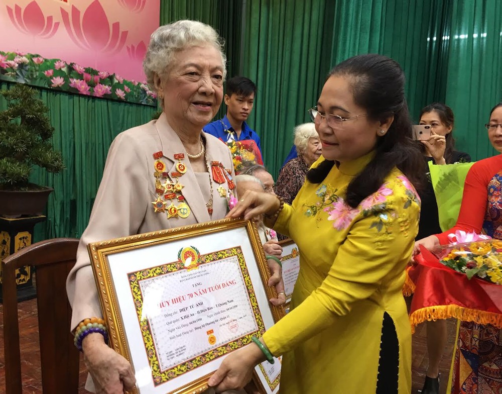 市委副书记、市人民议会主席阮氏丽向叶秀英大娘颁发70年党龄纪念章。