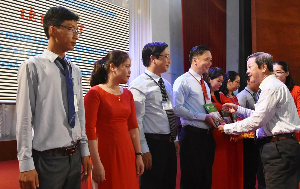 Ông Nguyễn Huy Cận, Chủ tịch Hội khuyến học TP trao quyết định cho ông Phan Văn Thanh Cần, Phó Hiệu trưởng Trường Cao đẳng Kinh tế - Kỹ thuật TPHCM