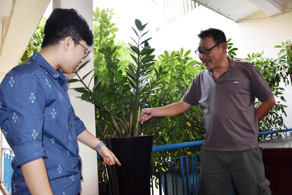 Nhà sáng chế “chân đất” Nguyễn Quang Ngọc (bìa phải) và cộng sự bên những cây lên xanh tốt với chậu trồng cây không cần tưới