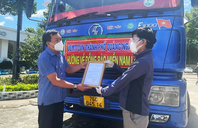 Đại diện UBMTTQ TP Quảng Ngãi (trái) trao quà cho đại diện người dân Quảng Ngãi tại TPHCM.