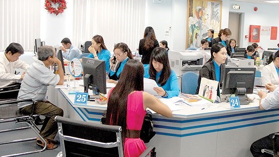 Clients do transactions at a bank in Ho Chi Minh City. (Photo: SGGP)