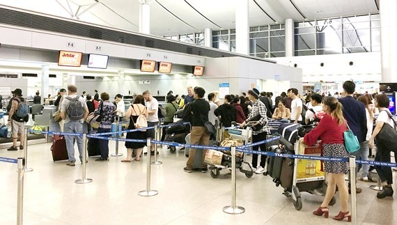 Passengers wait for luggage weighing at Tan Son Nhat International Airport. (Photo: SGGP)