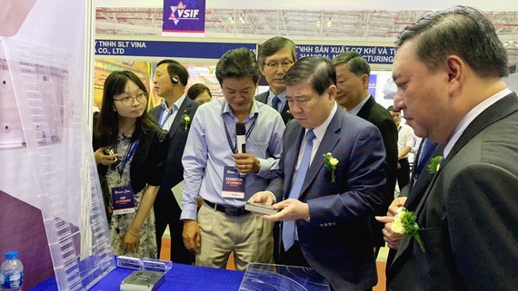 Mr. Nguyen Thanh Phong, chairman of HCMC People’s Committee, visits a stall of a Vietnamese supporting industry enterprise at the exhibition. (Photo: SGGP)