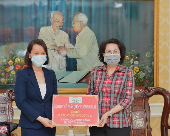Ms. To Thi Bich Chau receives a donation from the representative of a company. (Photo: SGGP)