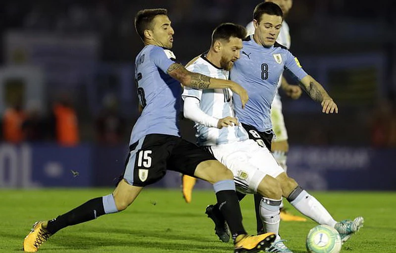 Messi trong vòng vây của hậu vệ Uruguay. Ảnh: AP