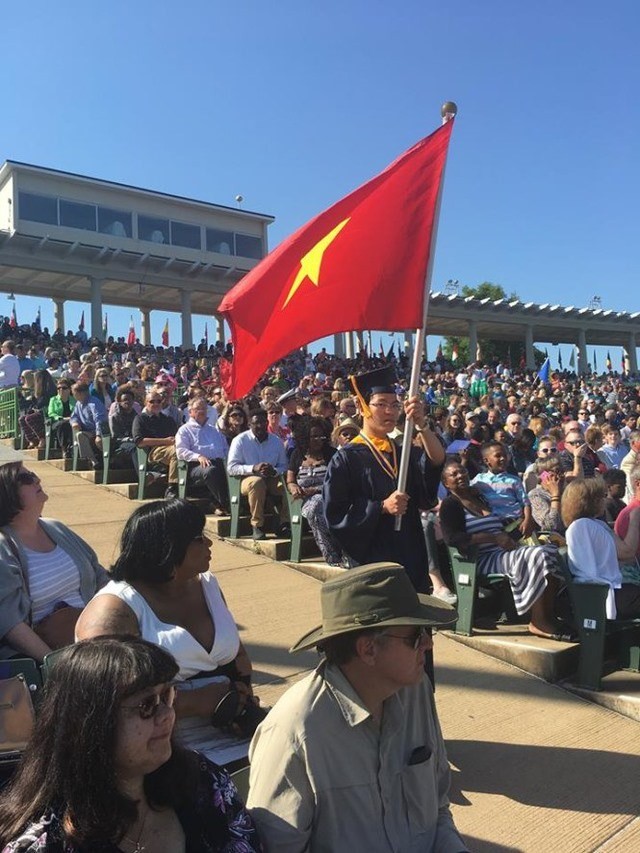 Le Quang Liem carries the Vietnamese flag at Webster University’s graduation ceremony in the US (Photo: dantri.com.vn)