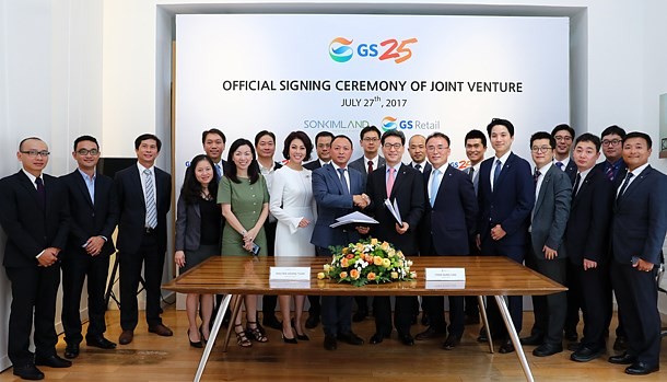 Son Kim Group Chairman Nguyen Hoang Tuan (center left) and GS25 CEO Cho Yoon-sung (center right) shake hands after the two companies signed a contract to jointly operate the convenience store chain in Ho Chi Minh City, Vietnam. (Source: GS RETAIL)