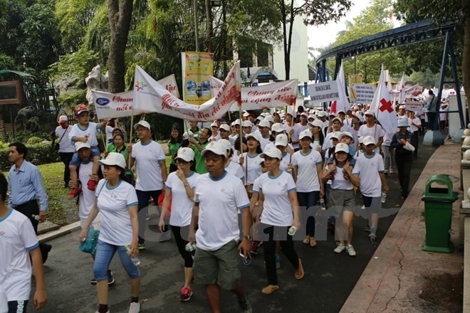 People walk to support AO victims (Source: VNA)