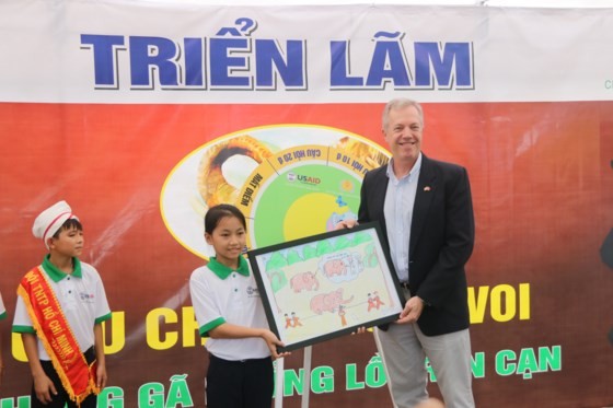 A student in Nong Son District presents a painting of wild elephants to U.S. Ambassador to Vietnam Ted Osius. (Photo: Sggp)