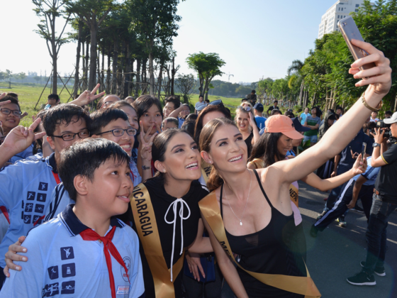 Beauties take selfie with young people in HCM City . (Photo: Sggp)