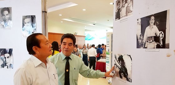 Former Secretary of the municipal Party Committee Le Thanh Hai (L) enjoys pictures in the exhibition. (Photo: Sggp)