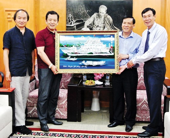 Representative of the SGGP Newspaper offers a painting as a gift to the CWA. (Photo: Sggp)