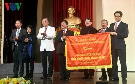 Deputy PM Vu Duc Dam offers certificate of merit to the Vietnam Musicians' Association. (Photo: VOV)