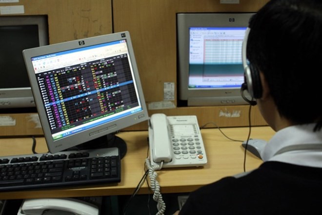 An underwriter monitors stock trades at the Hanoi Stock Exchange (Photo: VNA)