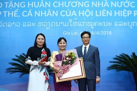 Deputy Prime Minister Vu Duc Dam (first, right) presents the Order of Independence, second class, to Inlavan Keobounphan, President of the Laos Women’s Union (centre). (Photo: news.chinhphu.vn) 
