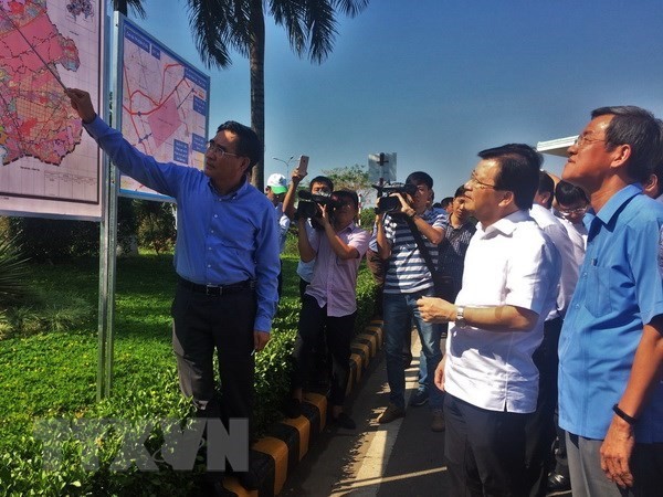 Deputy Prime Minister Trinh Dinh Dung (white shirt) and other officials listen to the introduction of Long Thanh project on April 12 (Photo: VNA)