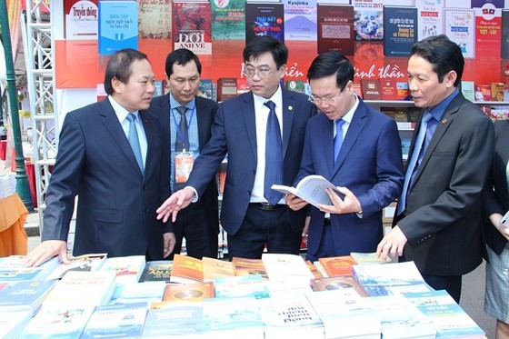 Politburo member and Head of the Party Central Committee's Commission for Communications and Education Vo Van Thuong (2nd, R) visits display booths at the 5th Vietnam Book Day. (Photo: Sggp)
