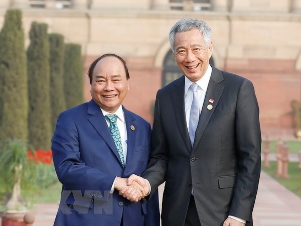 Prime Minister Nguyen Xuan Phuc (L) shakes hands with Singaporean PM Lee Hsien Loong (Photo: VNA)