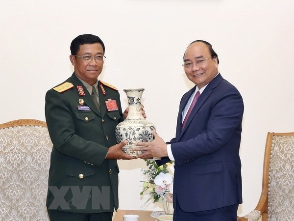 Prime Minister Nguyen Xuan Phuc (R) presents a gift to Sen. Lt. Gen. Suvon Luongbunmi, Deputy Defence Minister and Chief of the General Staff of the Lao People’s Army, at their meeting on May 14 (Photo: VNA)