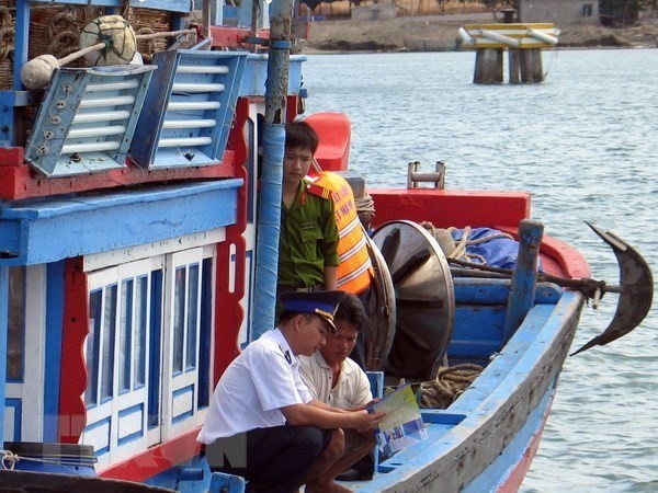 A law enforcement officer provides Ninh Thuan fishermen with fishing-related regulations (Source: VNA)