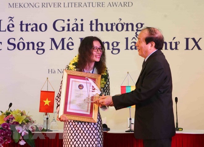 Poet Huu Thinh, President of Vietnam Union of Literary and Arts Associations  presents an award to a writer. (Photo: VNA)