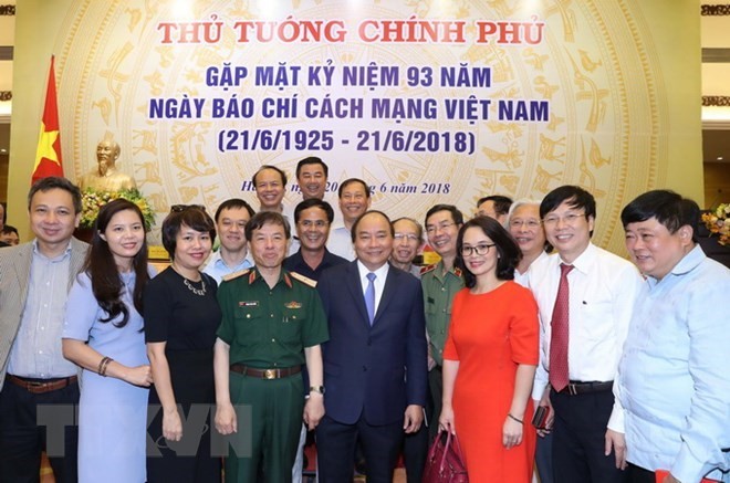 Prime Minister Nguyen Xuan Phuc (front, fourth, right) and representatives of press agencies pose for a photo at the meeting in Hanoi on June 20 (Photo: VNA)