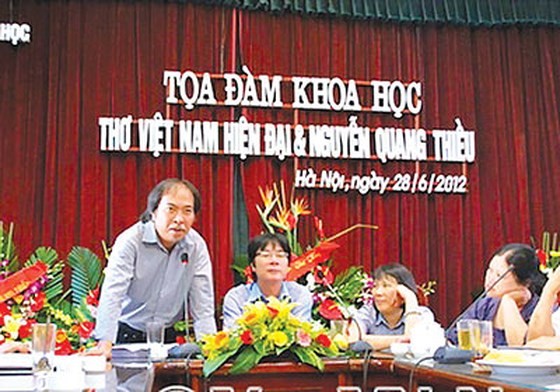 Poet Nguyen Quang Thieu (L) speaks at a seminar. (Photo: Sggp)
