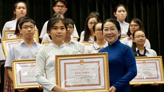 Vice Secretary of HCMC Party Committee Vo Thi Dung offers certificates of merit to students. (Photo: Sggp)