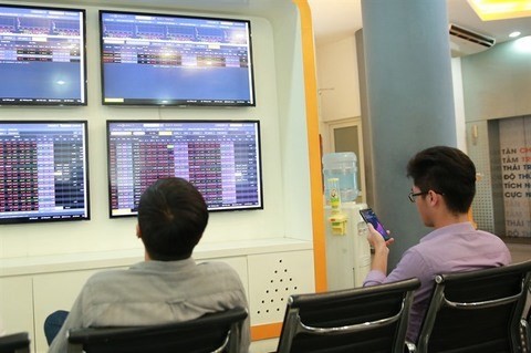 Two investors follow the stock index at the VNDirect Stock Exchange (Source: VNA)